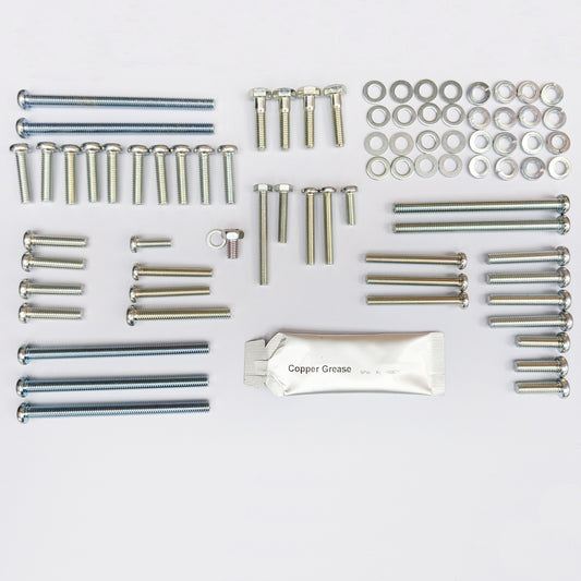 Collection of metal screws, bolts, and washers on a white background with a packet of copper grease. made into screw kit to fit a Suzuki GT380 from 1972 to 1977