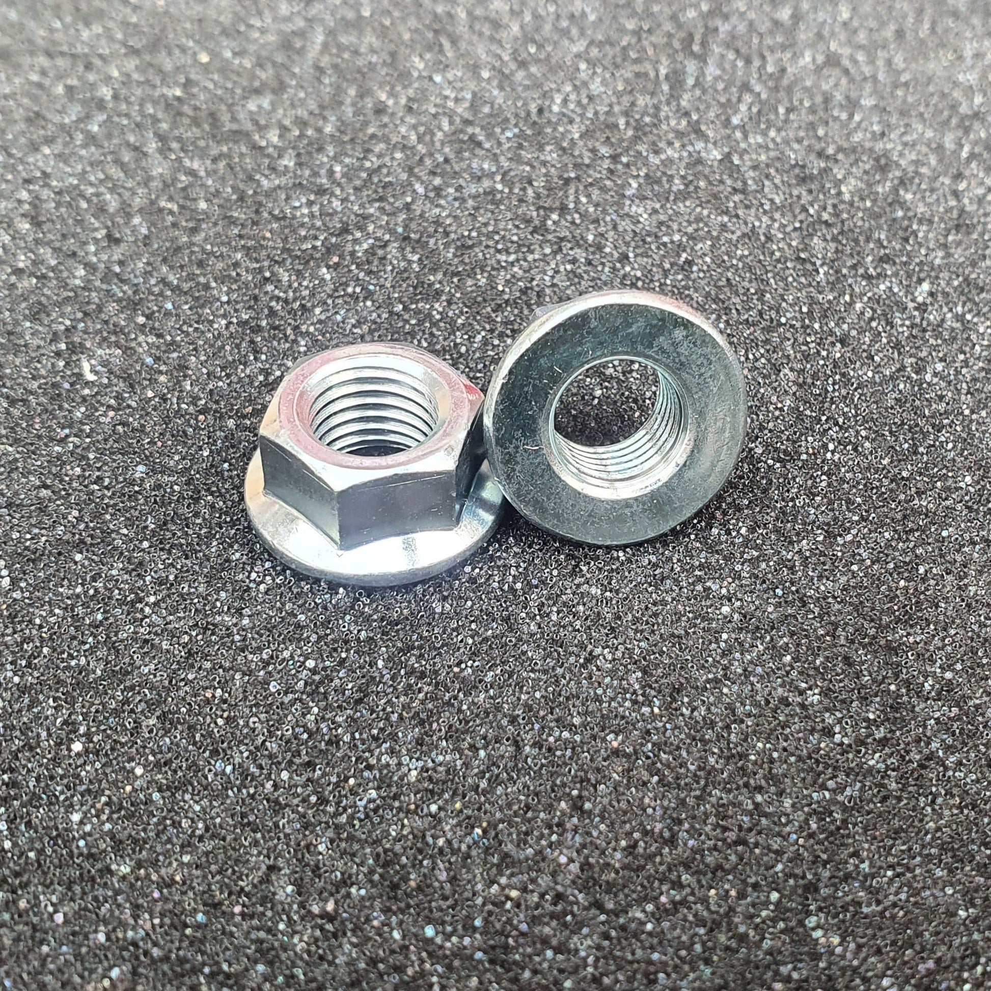 Two fine pitch plain flanged nuts with a trivalent white finish on a textured background.